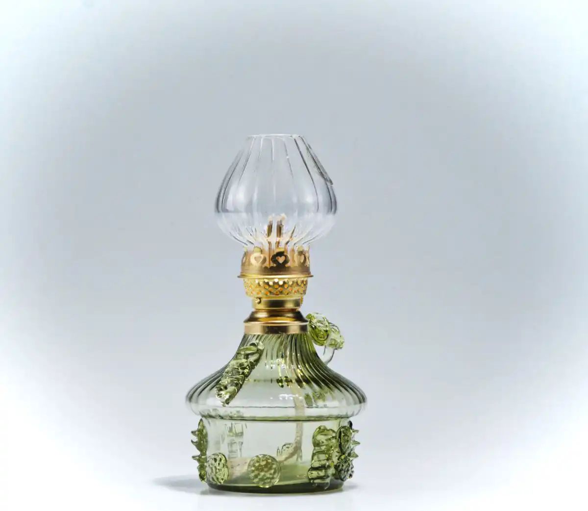 Ozdobná petrolejová lampa ze zeleného lesního skla.
